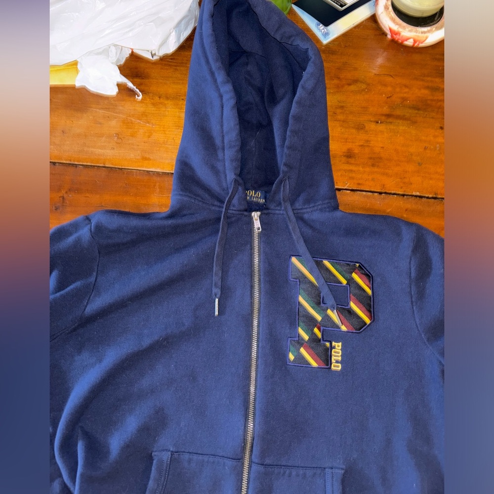 Medium polo Ralph Lauren zip up hoodie, and the color is blue with some designs